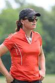 Woman in peak cap and sunglasses is wearing a red T-shirt.