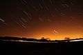 Short streaks of light on a dark sky, showing star trails that were photographed with a long exposure.