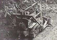 A bulldozer clears a path through the jungle