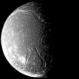 the dark face of Ariel, cut by valleys and marked by craters, appears half in sunlight and half in shadow