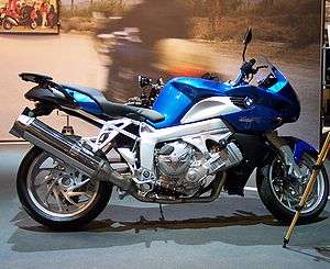 Blue BMW K1200R indoors with a promotional display in the background