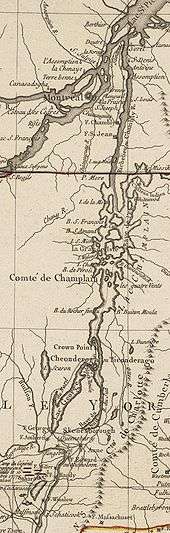 The map is oriented with north to the top. The lower section of the map shows Saratoga, New York and Fort Edward, on the Hudson River. There are red markers depicting the position of John Burgoyne's army near Saratoga at the time of its surrender in 1777. A line of mountains is shown to the right of the Hudson, extending northward but eventually bending off the map to the east. North of Fort Edward are Fort George, at the southern end of Lake George, and Skenesborough, near the southern end of Lake Champlain. About one third of the way up the map, Lake George joins with Champlain, and Fort Ticonderoga is shown at the northwest side of the junction. Lake Champlain extends to the north and is dotted with islands. There is a red line marking the boundary between New York and Quebec, and the upper third of the map shows the Richelieu River extending north to meet the Saint Lawrence River at Sorel, with Montreal southwest of that point.