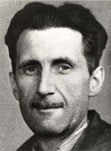 A photo showing the head and shoulders of a middle-aged man with black hair and a slim moustache.