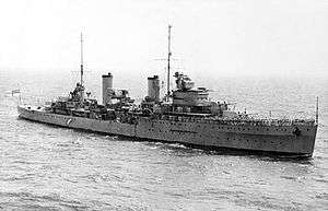 A black and white image of HMAS Sydney in open water.