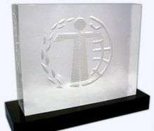 A Humanitas Prize trophy. A crystal sculpture engraved with the stylized image of a child standing with a laurel wreath and a world globe.