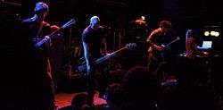 Isis performing live, on a moodily-lit stage.