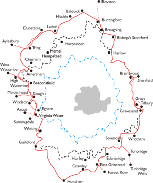 An outline map of the area around London. A series of concentric jagged lines donate various areas. Outermost is a red ring which is the area within which the LPTB controlled transport services. Within this are a dashed black line (area of monopoly powers), a dashed blue ring (Metropolitan Police District) and a grey shaded area (County of London). The names of towns around the perimeter of the red ring indicate its extent.