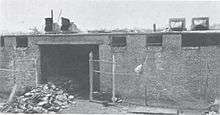A fire-damaged building with a pile of ruined film cans
