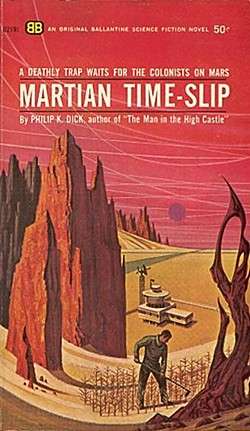 A man hoes a small garden on a Martian hill. Rock formations surround him. A building and a road are in the background.