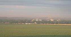 Town with grain elevators; crop field in foreground
